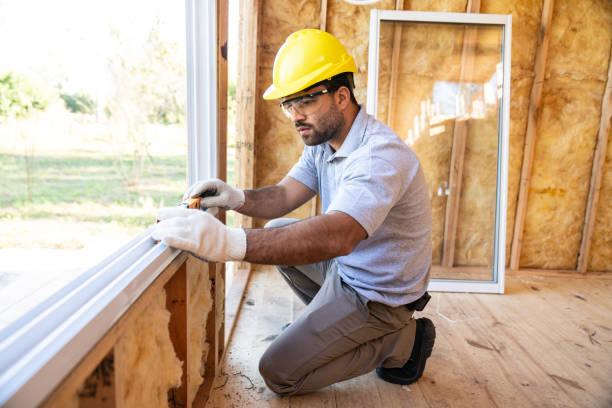 Window installation in wooden house under construction